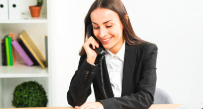 sorrindo-jovem-executiva-conversa-telefone-em-escritorio